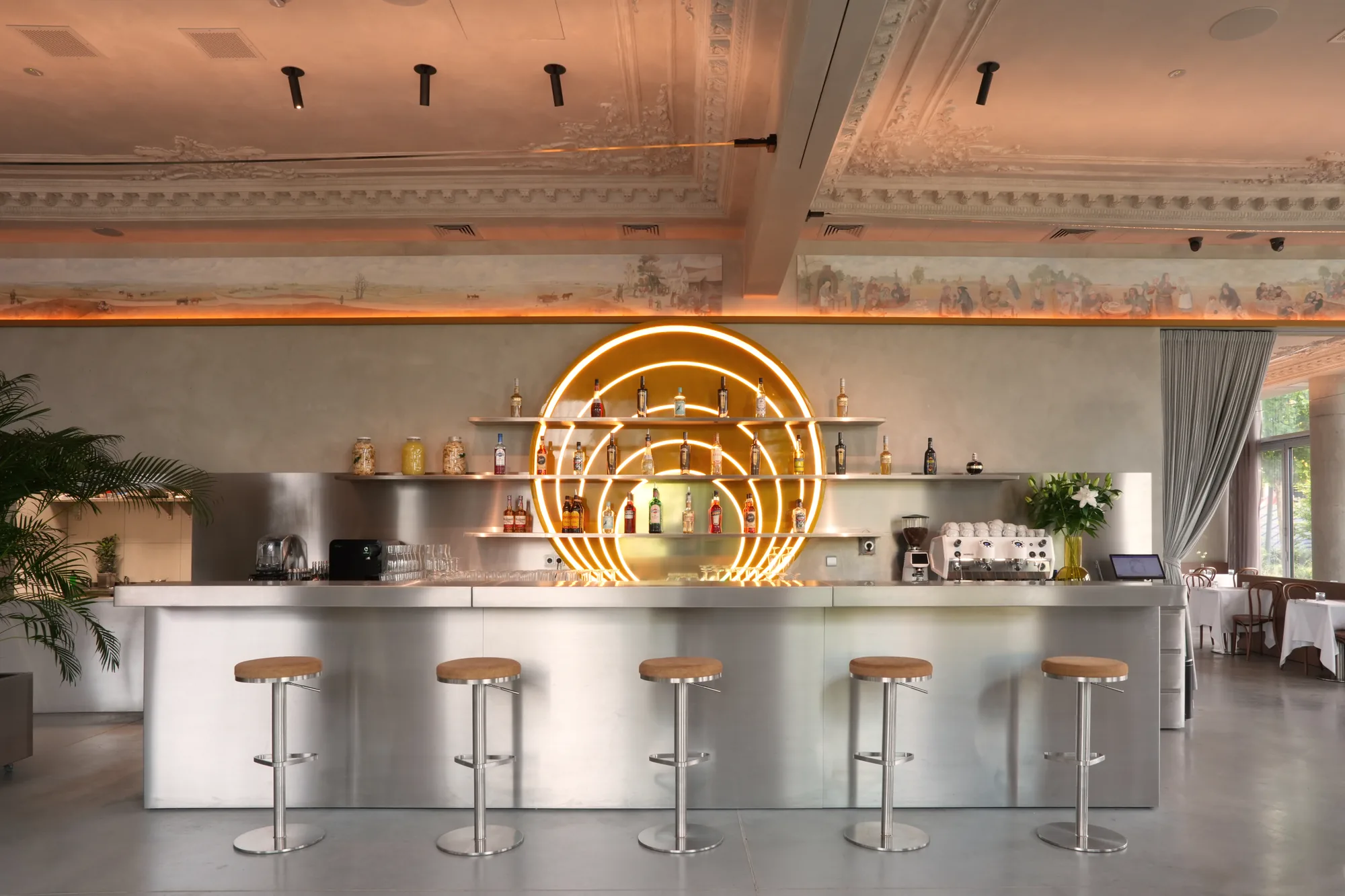 Instalacja barowa Słońce w restauracji Babajaga — podświetlane łuki LED nad stalowym barem