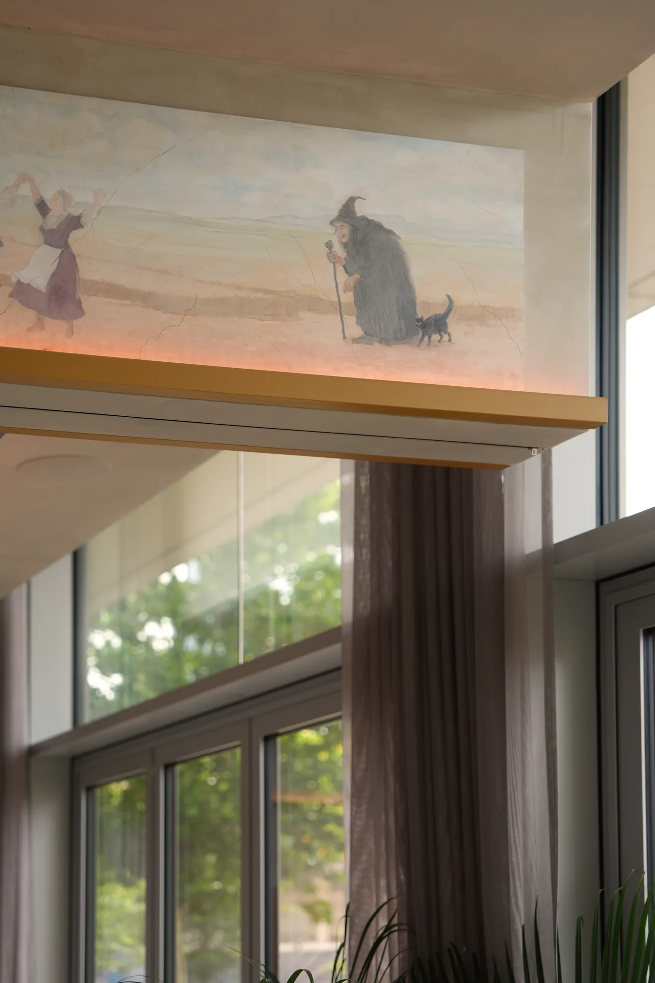 Scena fresku z Babą Jagą i czarnym kotem nad przeszkleniem restauracji
