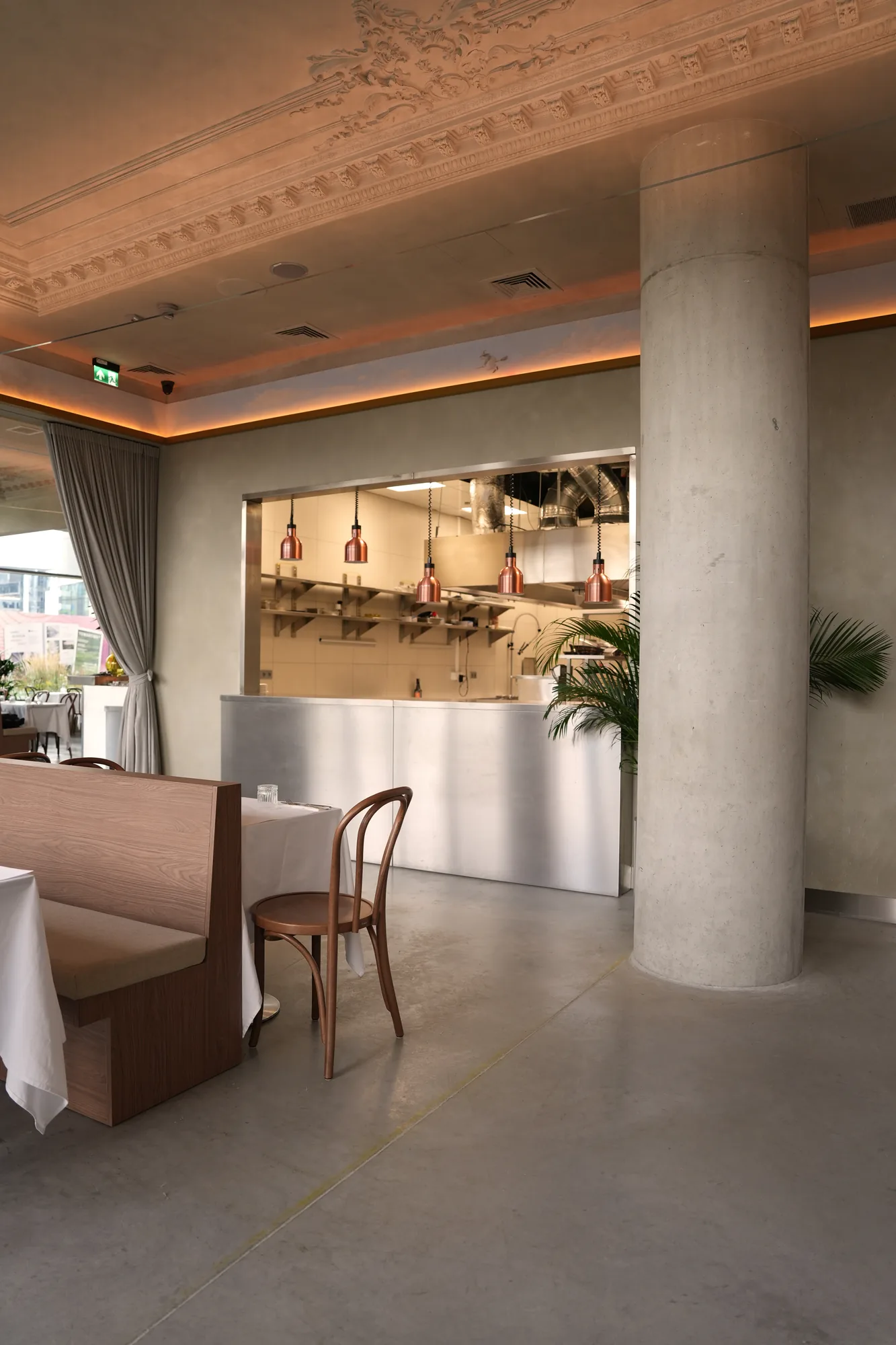 Sala główna restauracji Babajaga z otwartą kuchnią i betonową kolumną