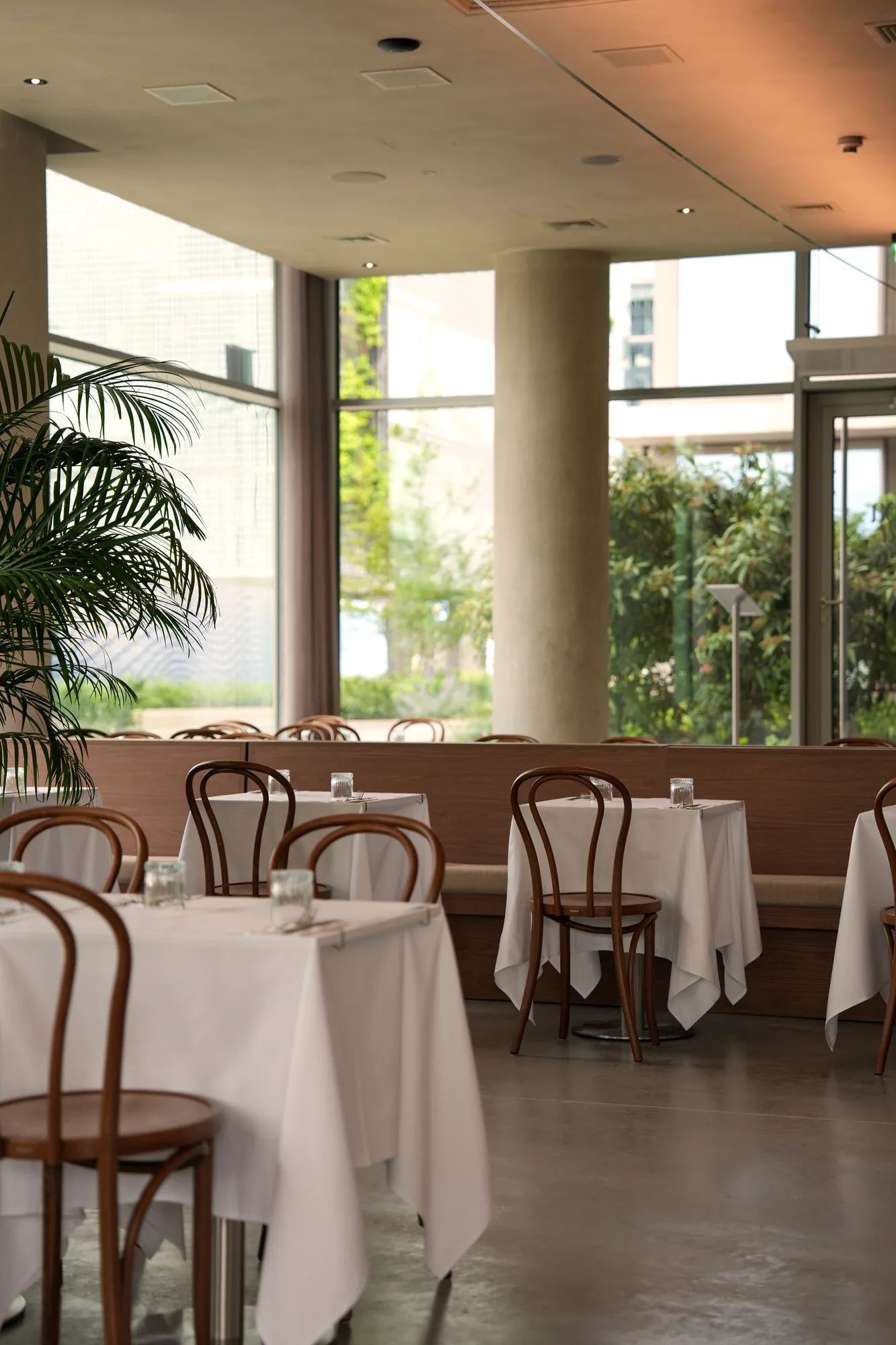 Strefa przy przeszkleniu z ławami i stolikami w restauracji Babajaga