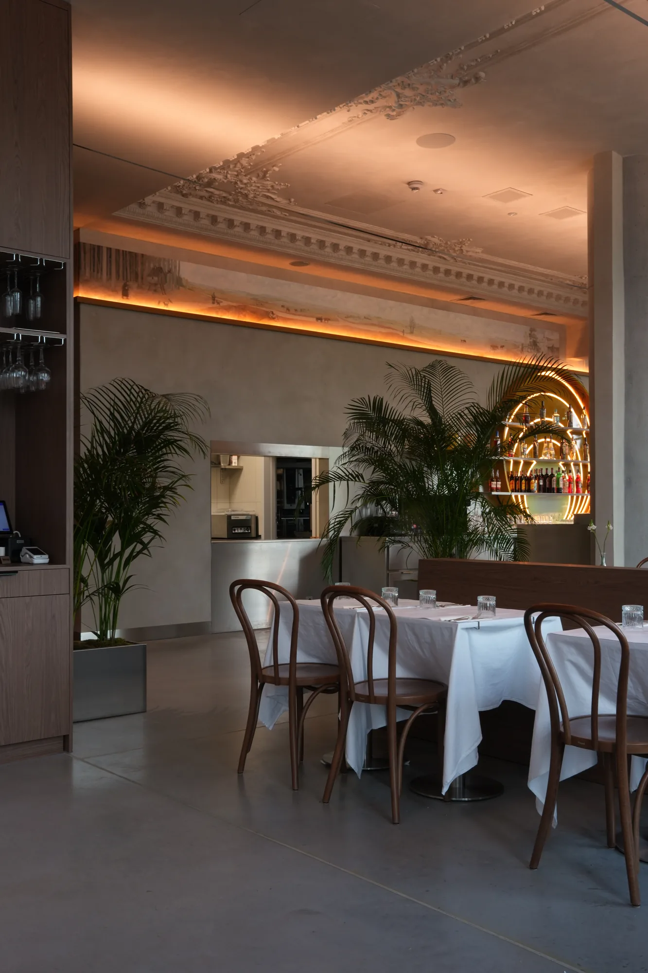 Wnętrze restauracji Babajaga wieczorem — podświetlony fresk i bar Słońce w tle