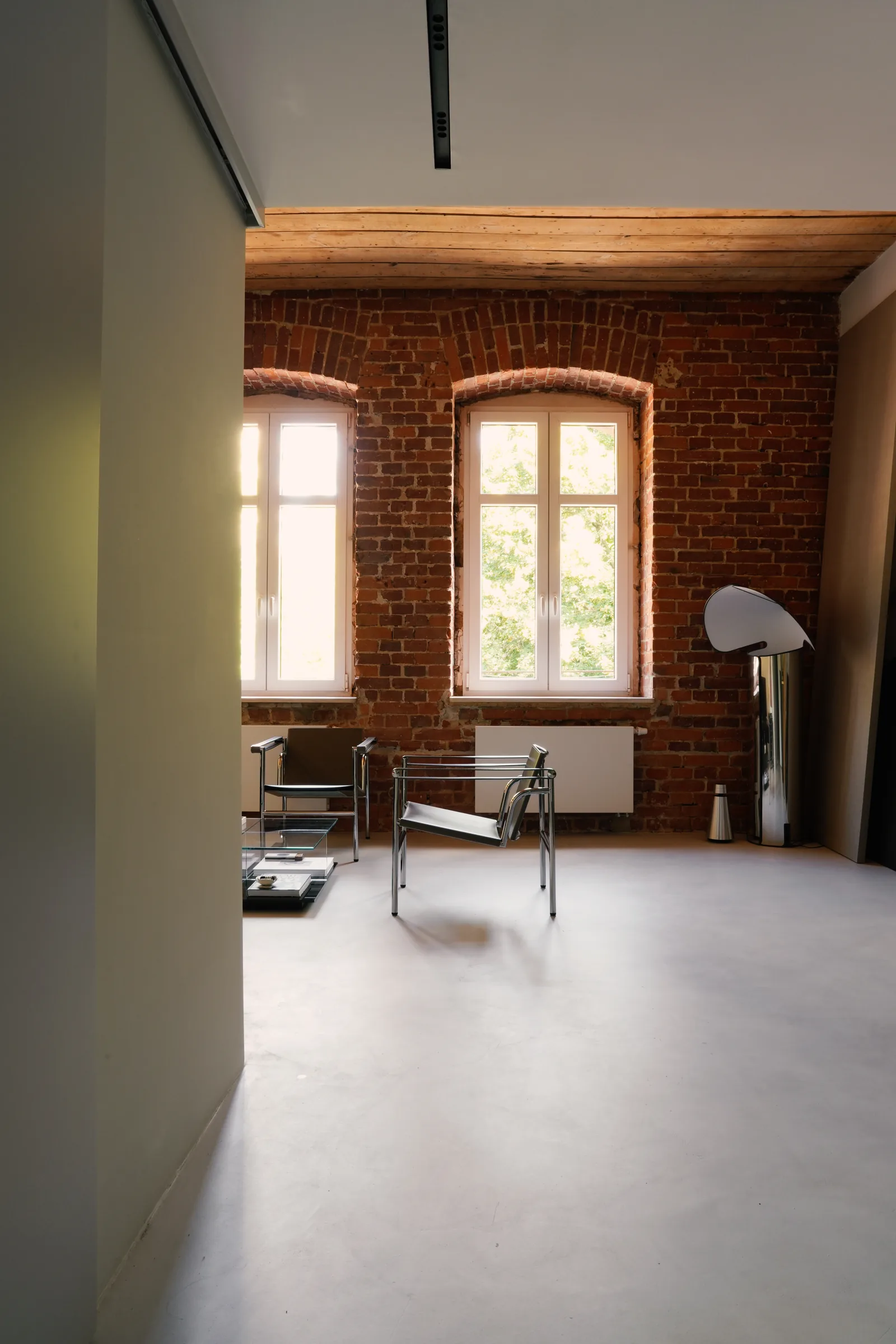 Lampa Flos Chiara przy łukowych oknach w ceglanej ścianie